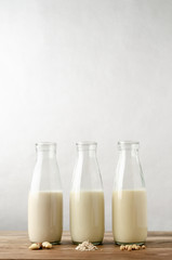 Non Dairy Milk Drinks in Glass Bottles on Wood