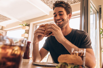 Young guy having stacked burger