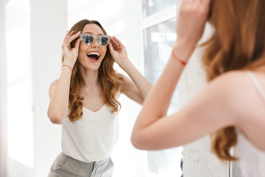 Cheerful Young Woman Trying On New Sunglasses