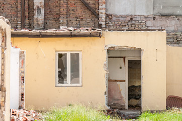 Interior remains of hurricane or earthquake disaster damage on ruined old house in the city with collapsed walls, roof and bricks with selective focus