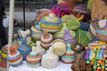 Display of small colorful hand woven baskets on a stall in a street market arranged in a jumble on a table in a close up view