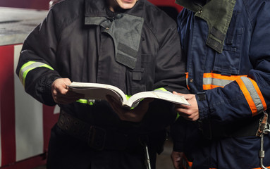 Fireman (firefighter) in action standing  near a firetruck. Emergency safety. Protection, rescue from danger.