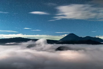 Tuinposter starry sky in the landscape with volcanoes in the clouds, Volcano Bromo National Park © YARphotographer