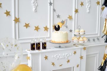 Cake for birthday party. Decorations for birthday party gold and white colors. 