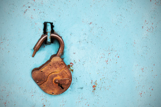 Old rusty lock without a key on a blue background