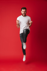 Handsome young man jumping showing winner gesture.