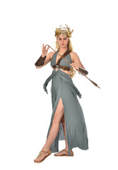 full length portrait of pretty blonde lady wearing fantasy toga gown,  and holding a bow and arrow. standing pose on white background.