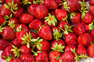 A lot of fresh red strawberries with green tails
