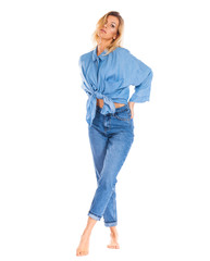 Young woman in blue jeans standing isolated on a white background