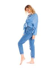 Young woman in blue jeans standing isolated on a white background
