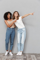 Full length portrait of two cheerful young women