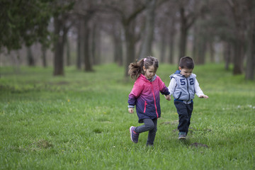 Fototapeta premium Boy and girl running in park