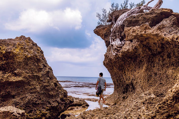 Young male tourist at Neil island sea beach Andaman India with natural rock formations.