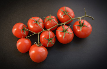 Natural-looking tomatoes on dark background. Selective focus.