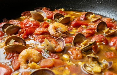 Shrimp in a tomato sauce with mollusks. Italian cuisine. seafood closeup.