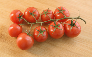 Natural-looking tomatoes on wooden background. Selective focus.