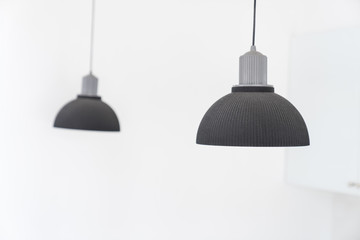 Interior design concept, modern pendant lamps hanging in a white room.