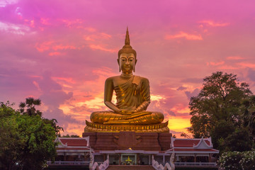 Silhouette big  golden buddha statue sitting  in thai temple  in sunset time 