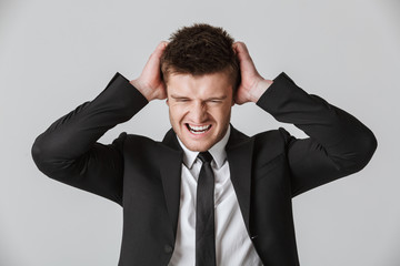 Portrait of an irrirtated young businessman in suit