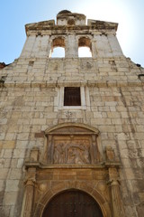 Obraz premium Beautiful Front Facade Of The Church Of Alcala De Henares University With A Nest Of Storks In Its Old Bell Tower. Architecture Travel History. May 5, 2018. Alcala De Henares Madrid Spain.