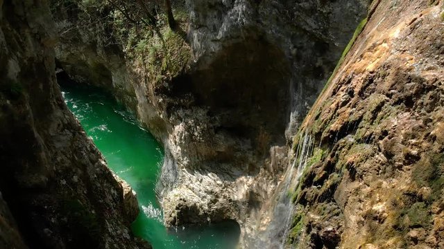Airial flight over the gorge with a waterfall and a mountain river