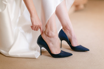 Blue beautiful bride shoes- wedding details. close up view woman Puts on wedding shoes.