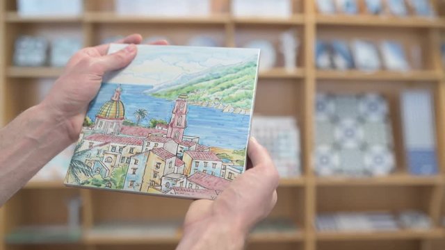 Male hands inspecting a ceramic tile