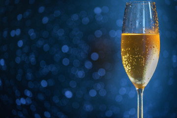 A glass of champagne on the right side of the frame on a blue blurred background