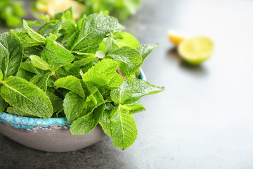 Bowl with fresh aromatic mint on table