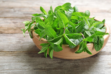 Bowl with fresh mint on wooden table