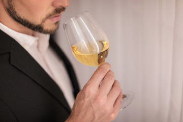 Young man with glass of wine indoors