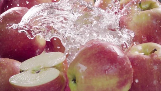 Red apple falling in juice with splash between apples. Slow motion
