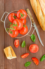 Frische Tomaten liegen in einer Schale auf einem Holztablett