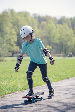 Little girl riding on skateboard.