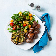 plate with dinner or lunch of baked potato, salad of tomato and