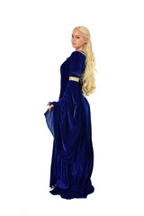 Fototapeta premium full length portrait of pretty blonde lady wearing a blue fantasy medieval gown. standing pose on white background.