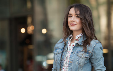 Fototapeta premium Young beautiful stylish girl walking and posing in short summer dress in city. Outdoor summer portrait of young woman