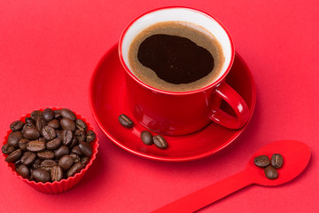 red cup with a drink of coffee with foam on a red background