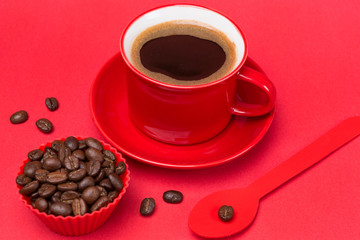 red cup with a drink of coffee with foam on a red background