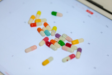 close up of colorful pill on calendar screen