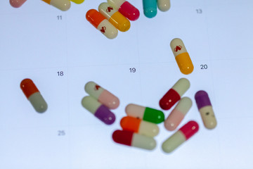 close up of colorful pill on calendar screen