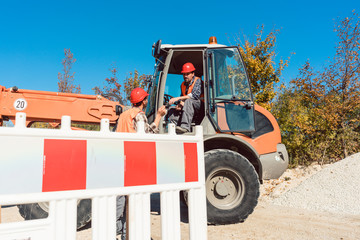 Construction worker starting road works on site with machine
