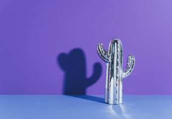 Creative golden cactus on ultraviolet background.