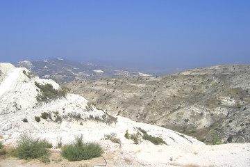 snow-white limestone canyon, desert landscape of Cyprus; distant mountains in a blue haze; blurred...