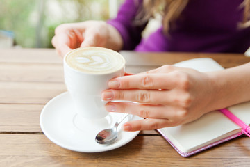 Hands writting at notebook in cafe