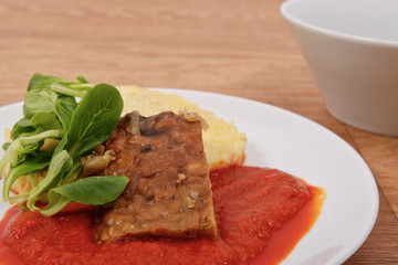 Tempeh with tomato sauce and dumplings on a table