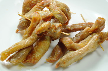 fried slice pork stabbing with wooden stick on plate