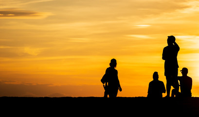 Fototapeta na wymiar Groups of silhouette people Do activity on the beach on the Sunset and show the posture during a vacation at the tropical beach in travel and holiday concept.