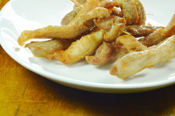 fried slice pork stabbing with wooden stick on plate