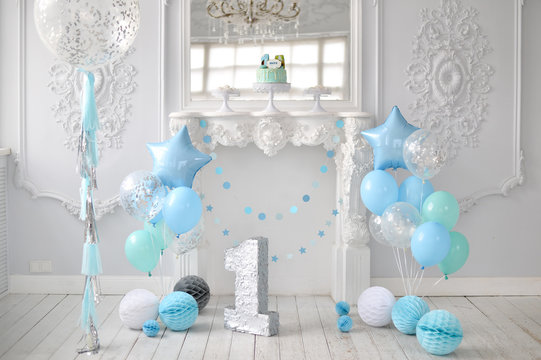 One year birthday decorations. A lot of balloons blue and white colors. Blue stars. Big Balloons. Cake for holiday party. 